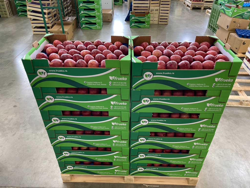 naslagane gajbe sa crvenim jabukama